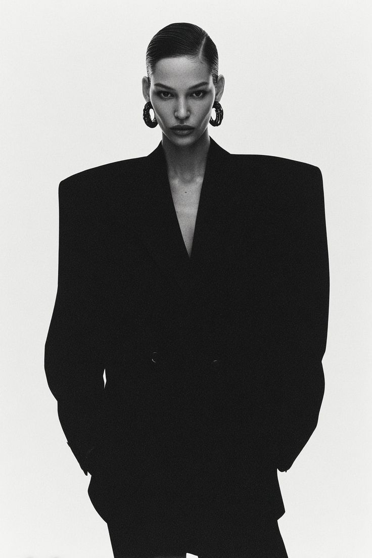 Black-and-white editorial portrait in an oversized black blazer